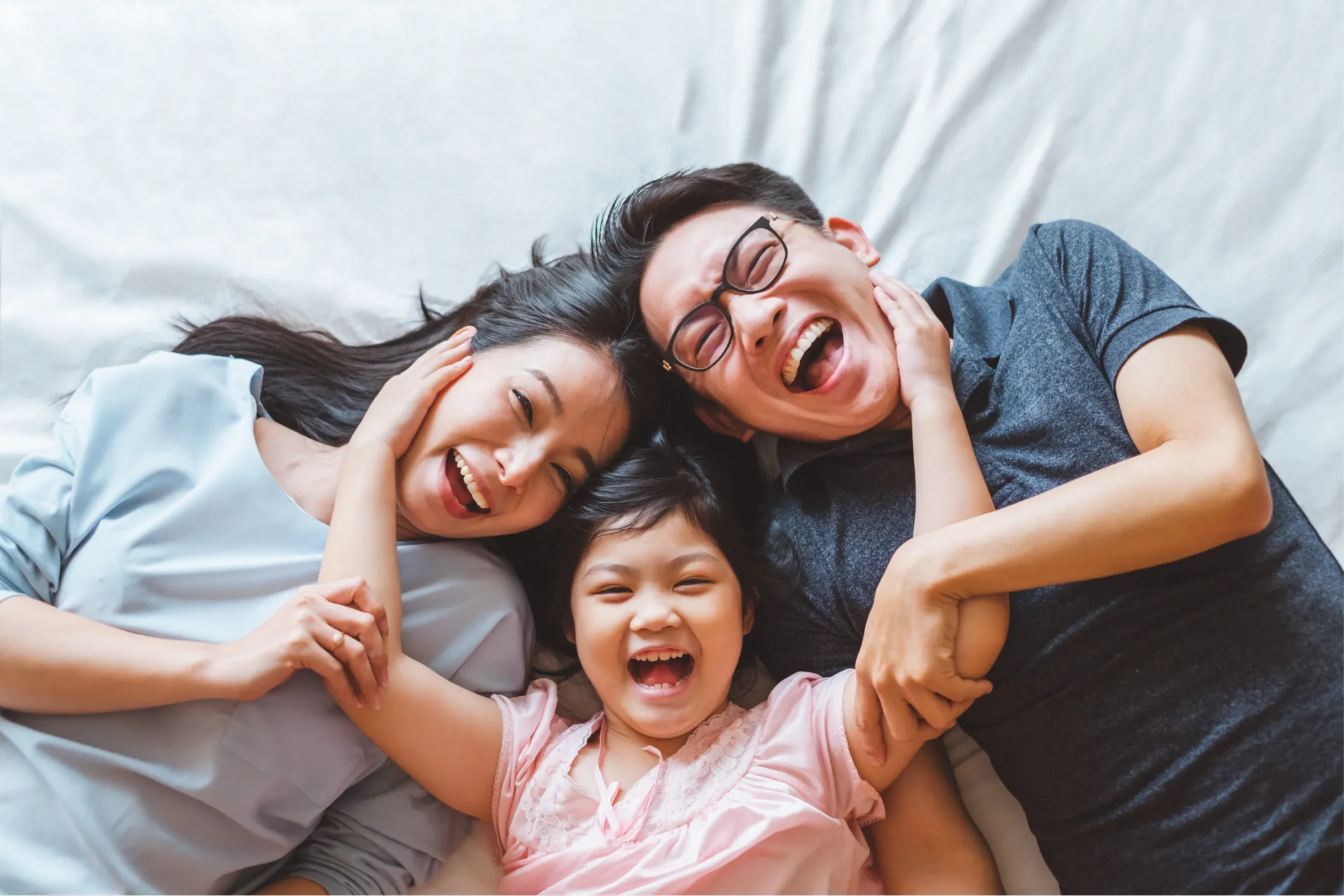 Family laughing together — parents and child sharing a joyful moment