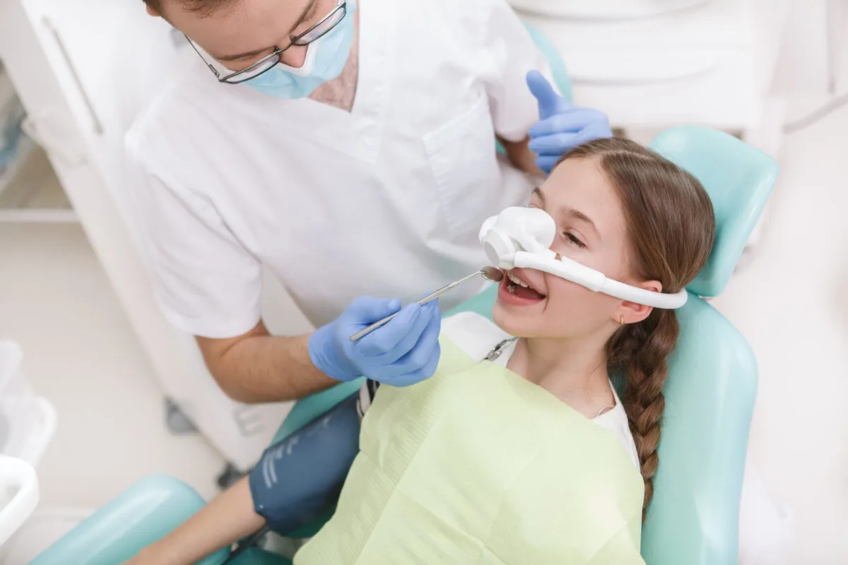Child receiving dental care with nitrous oxide sedation